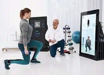 Patientin trainiert mit Therapeut vor der digitalen Pixformance Station