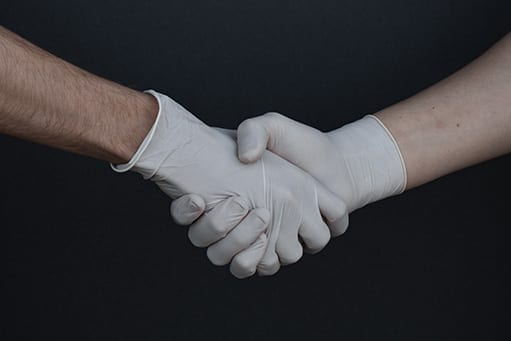 Händedruck mit Handschuhen: In der Coronakrise greifen viele Therapeuten auf digitale Möglichkeiten zurück.